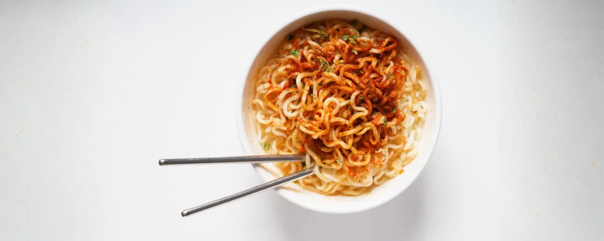 Noodles mayonaise ei; noodles in een kom met stokjes.