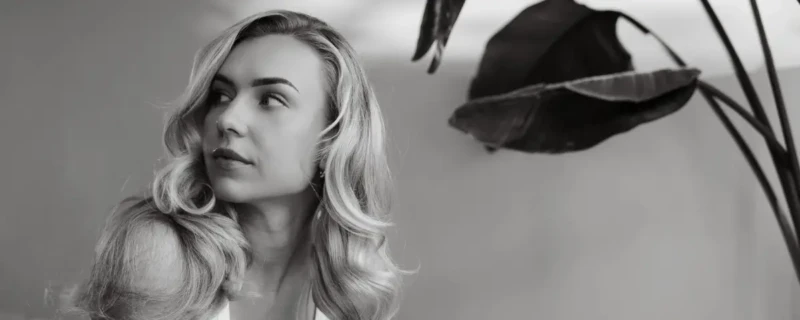 Shoot Joy Beune; Joy Beune liggend op een bank met plant in de achtegrond, terwijl ze gefotografeerd wordt voor Helden Magazine.