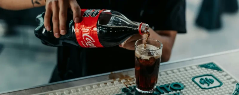 Geheime recept coca-cola; Coca-Cola cola wordt uitgeschonken uit een fles in een fles aan een bar.