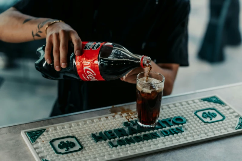 Geheime recept coca-cola; Coca-Cola cola wordt uitgeschonken uit een fles in een fles aan een bar.