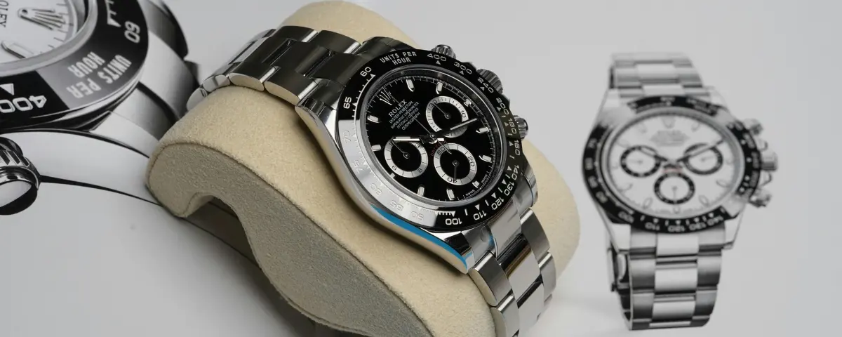 Rolex verkoop; Rolex Daytona liggend op koffieboek met Rolex-print op de pagina.