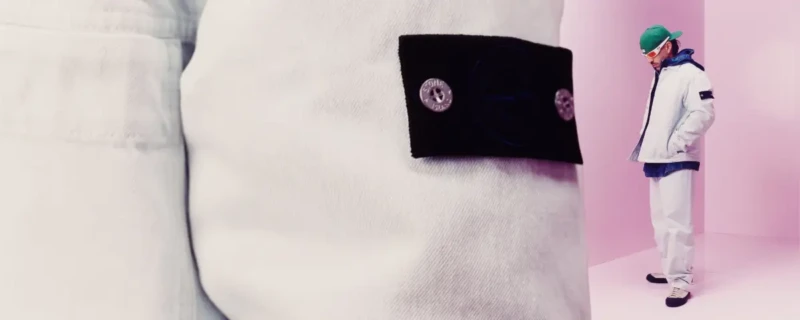 Stone Island 2026; spijkerjack van Stone Island gefotografeerd tegen roze achtergrond.