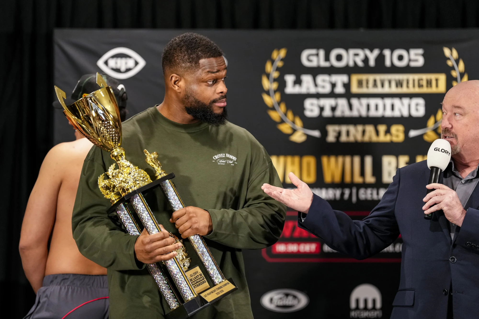 GLORY 107; Tariq 'Cookie' Osaro poserend met een beker in z'n hand. 