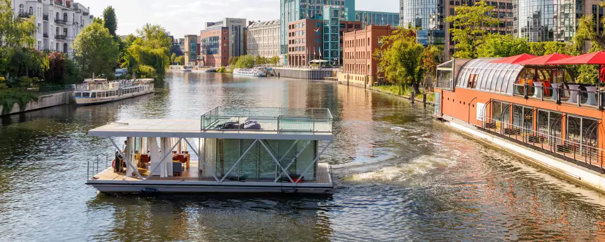 Woonboot Berlijn; Airbnb NIDO by PATIO gefotografeerd op de Spree in Berlijn vanaf de buitenkant.