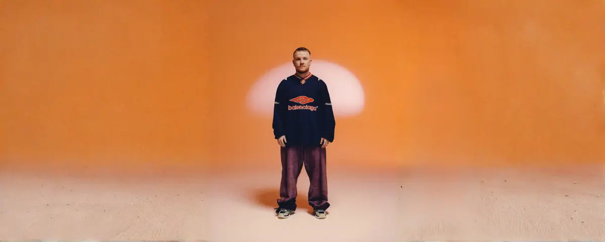 Chris Stussy Lost, Found & Forgotten; Chris Stussy poserend in een oranje studio.